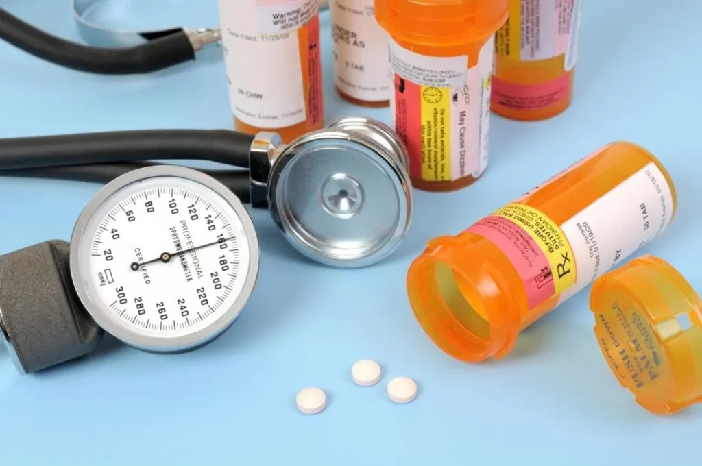 bottles of pills with a stethoscope and blood pressure meter 11zon